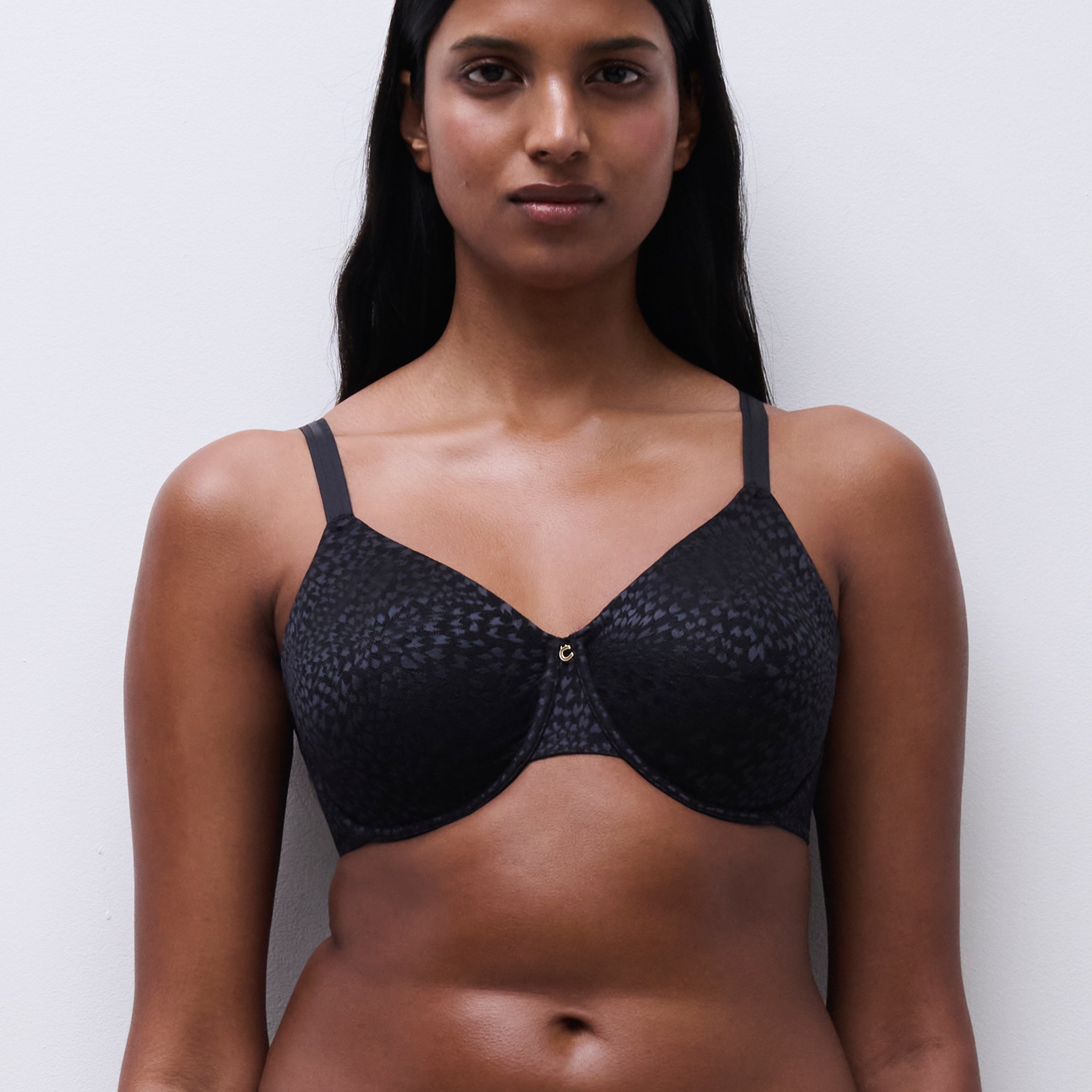 Front view of a woman wearing the Magique minimizer bra in black, showing supportive unlined cups and adjustable straps