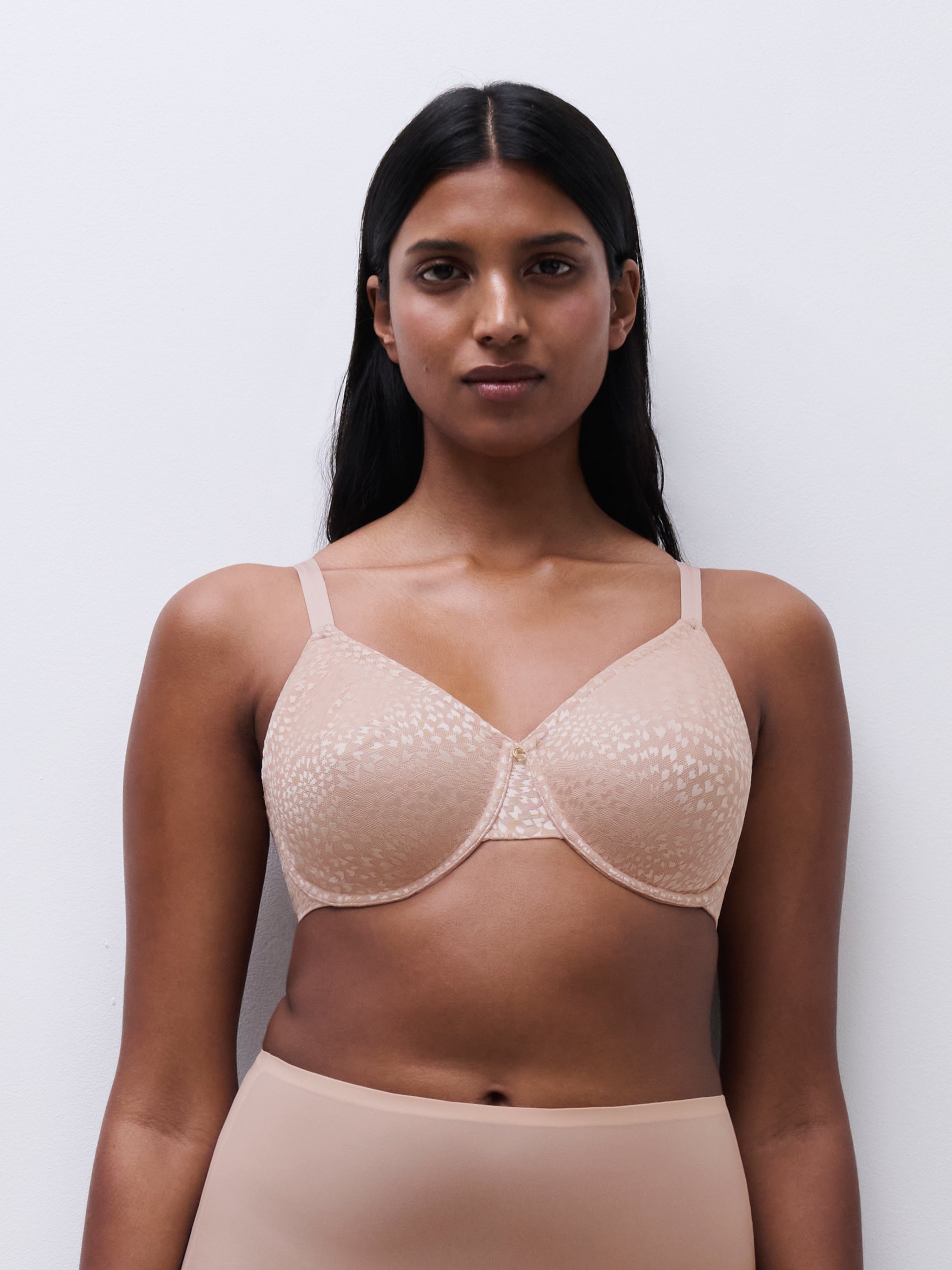 Front view of a woman wearing the Magique minimizer bra in rose, showing full-coverage unlined cups and supportive underwire